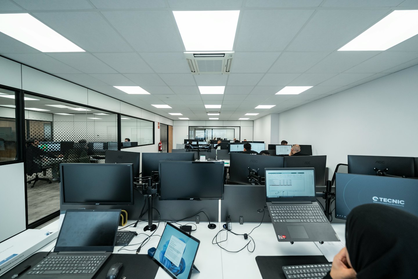 Persone che lavorano al computer in un moderno ufficio open space.